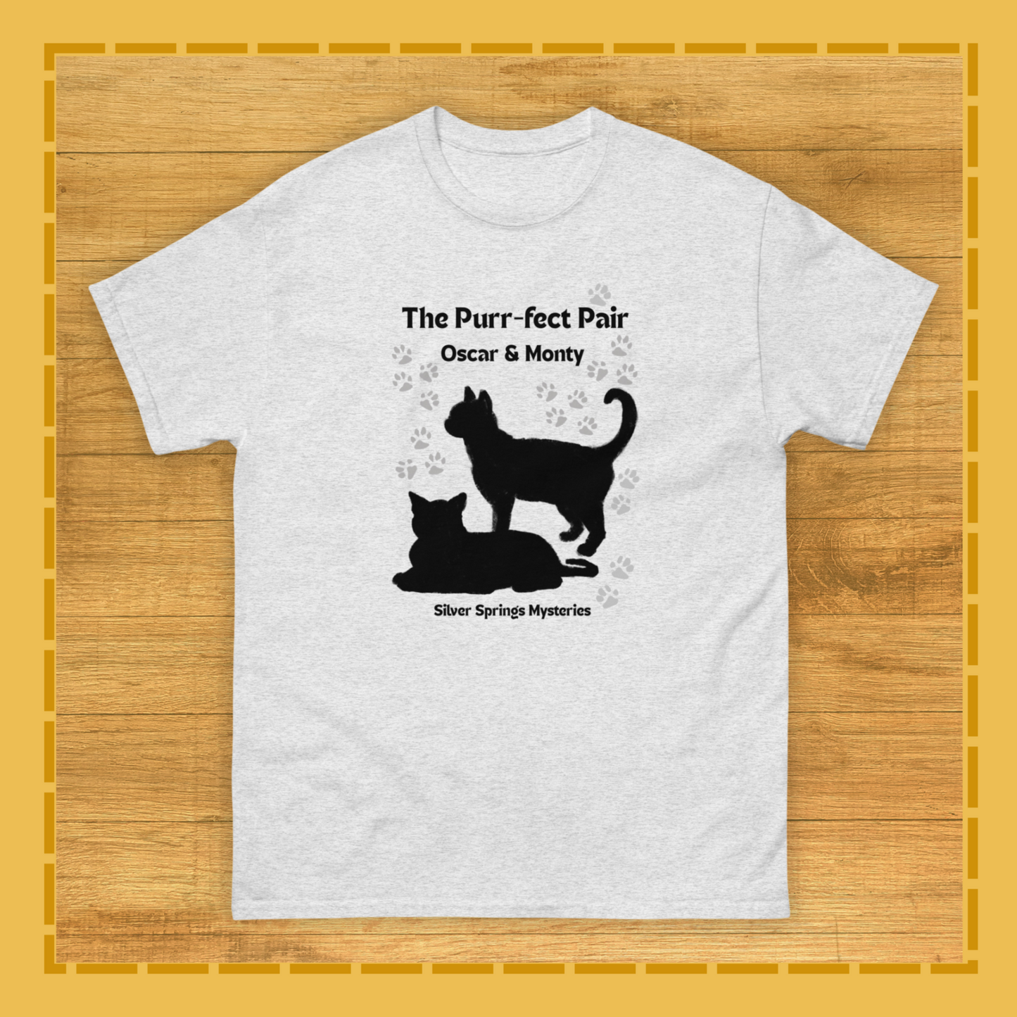White t-shirt with black cat silhouette design on a wooden surface