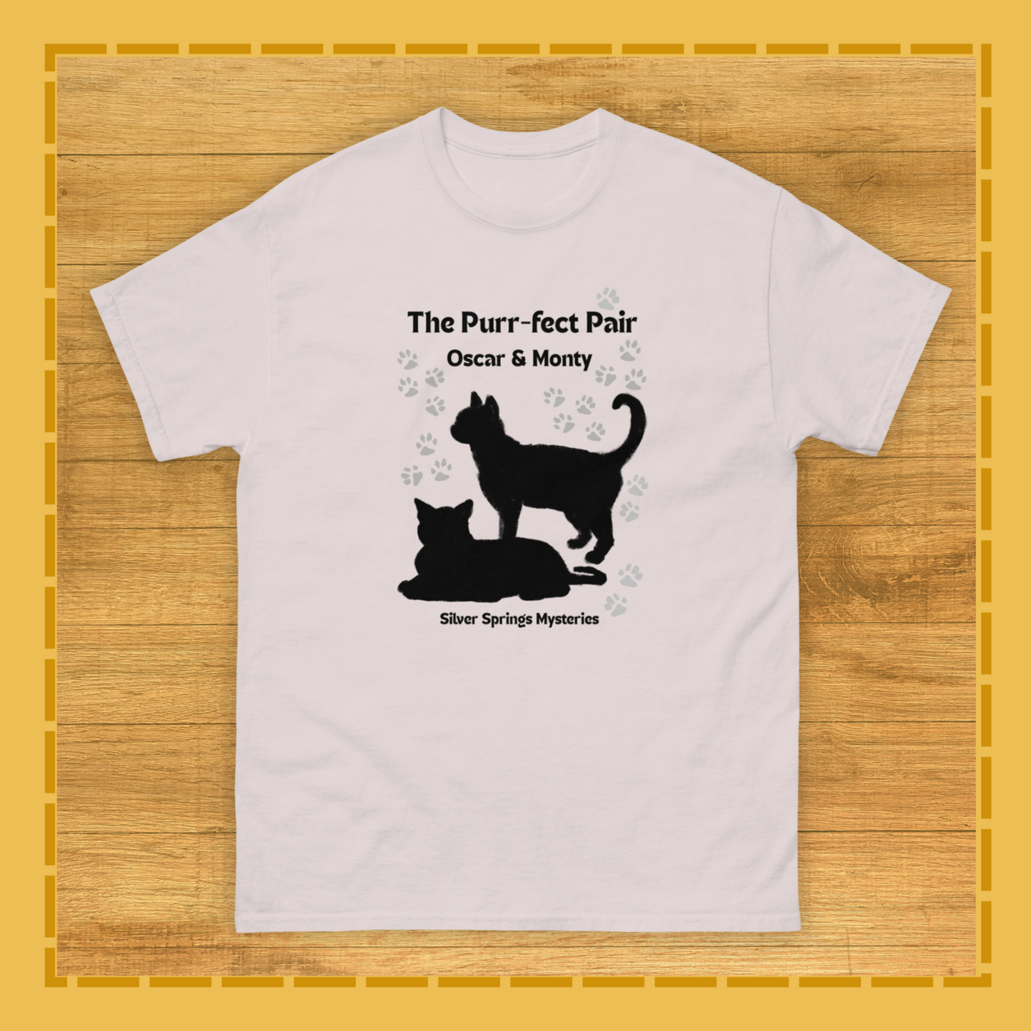 White t-shirt with black cat silhouette design on a wooden surface