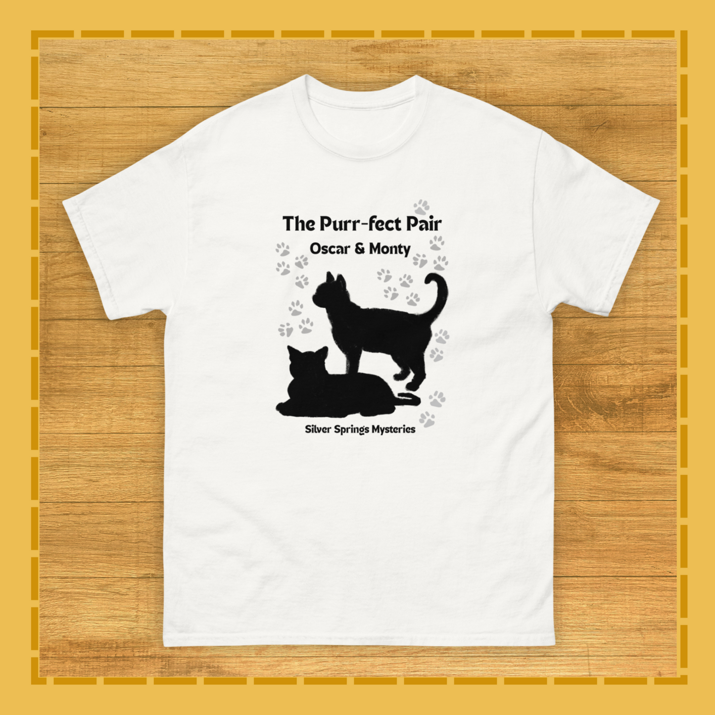 White t-shirt with black cat design and text on a wooden surface
