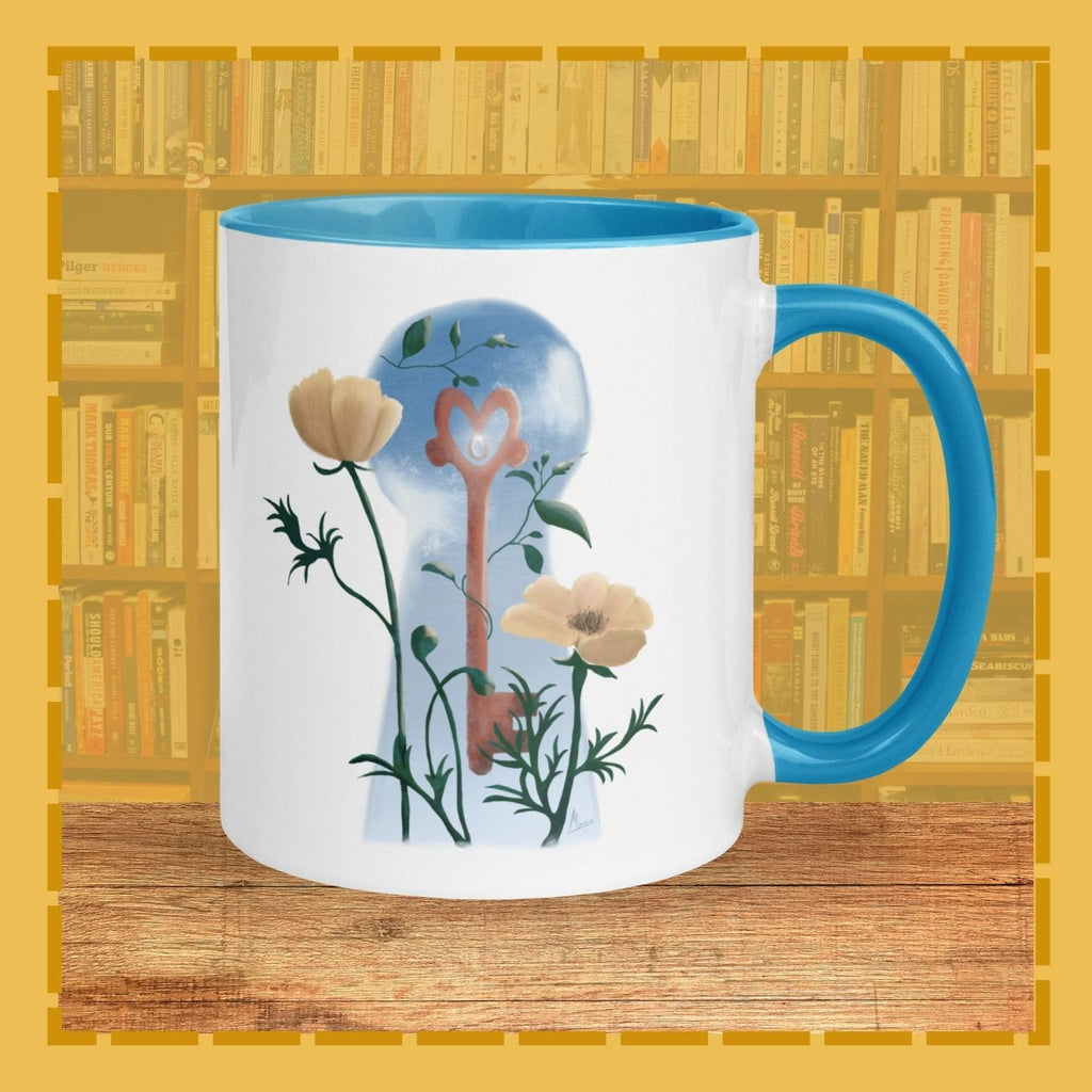 Mug with floral design and blue handle on a wooden surface with bookshelf background