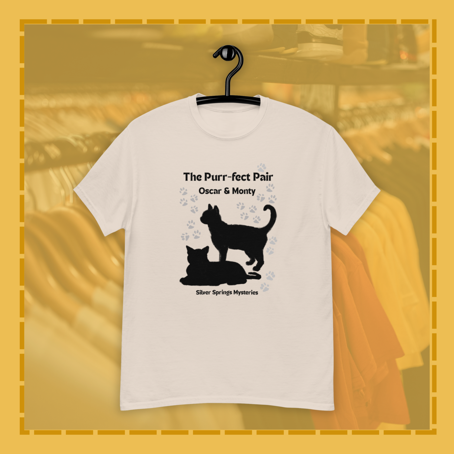 White t-shirt with black cat design and text on a hanger against a blurred background