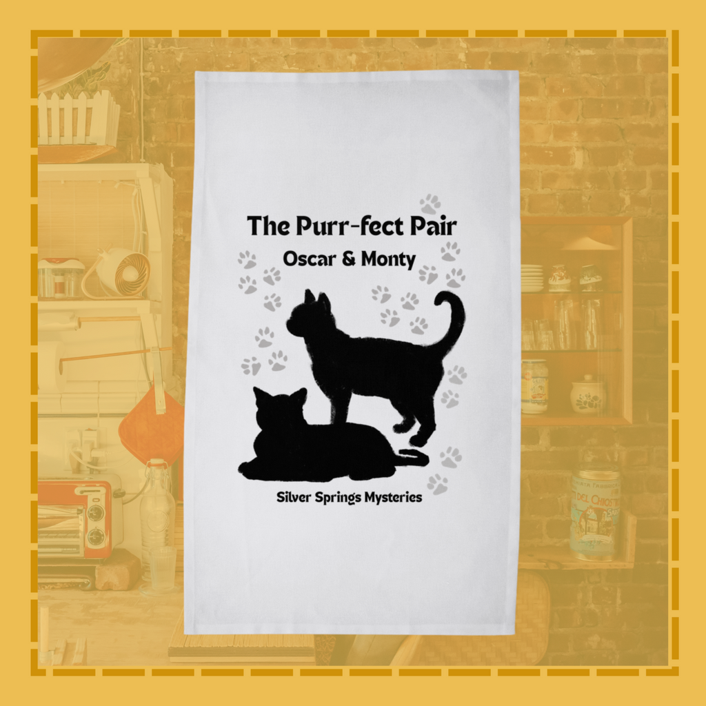 Tea towel with black cat silhouettes and text on a white background, set against a vintage-style bookshelf.
