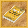 Book titled 'Murder at the Summer Cheese Festival' on a wooden surface
