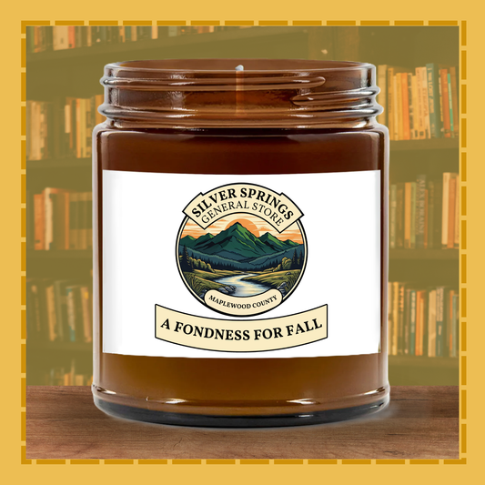 Jar of candle labeled 'A Fondness for Fall' by Silver Springs General Store with a bookshelf background.