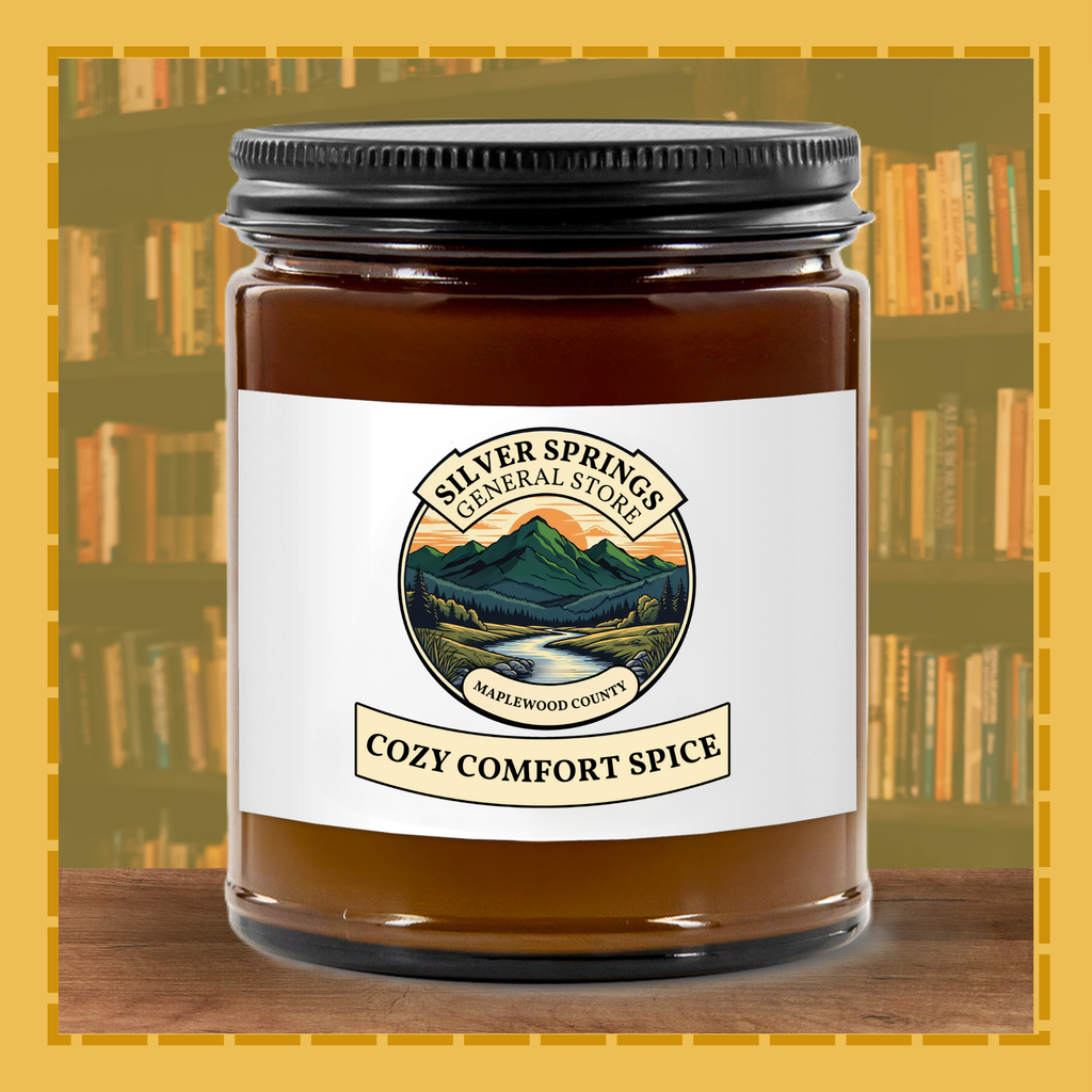 Jar of 'Cozy Comfort Spice' candle with a scenic label on a bookshelf background
