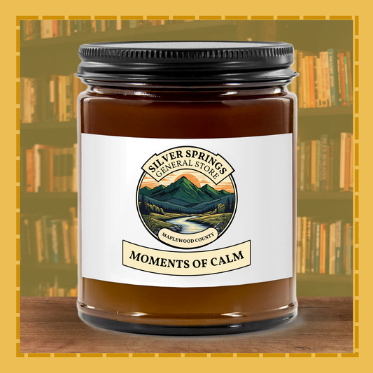 Candle jar labeled 'Moments of Calm' from Silver Springs General Store with a bookshelf background.